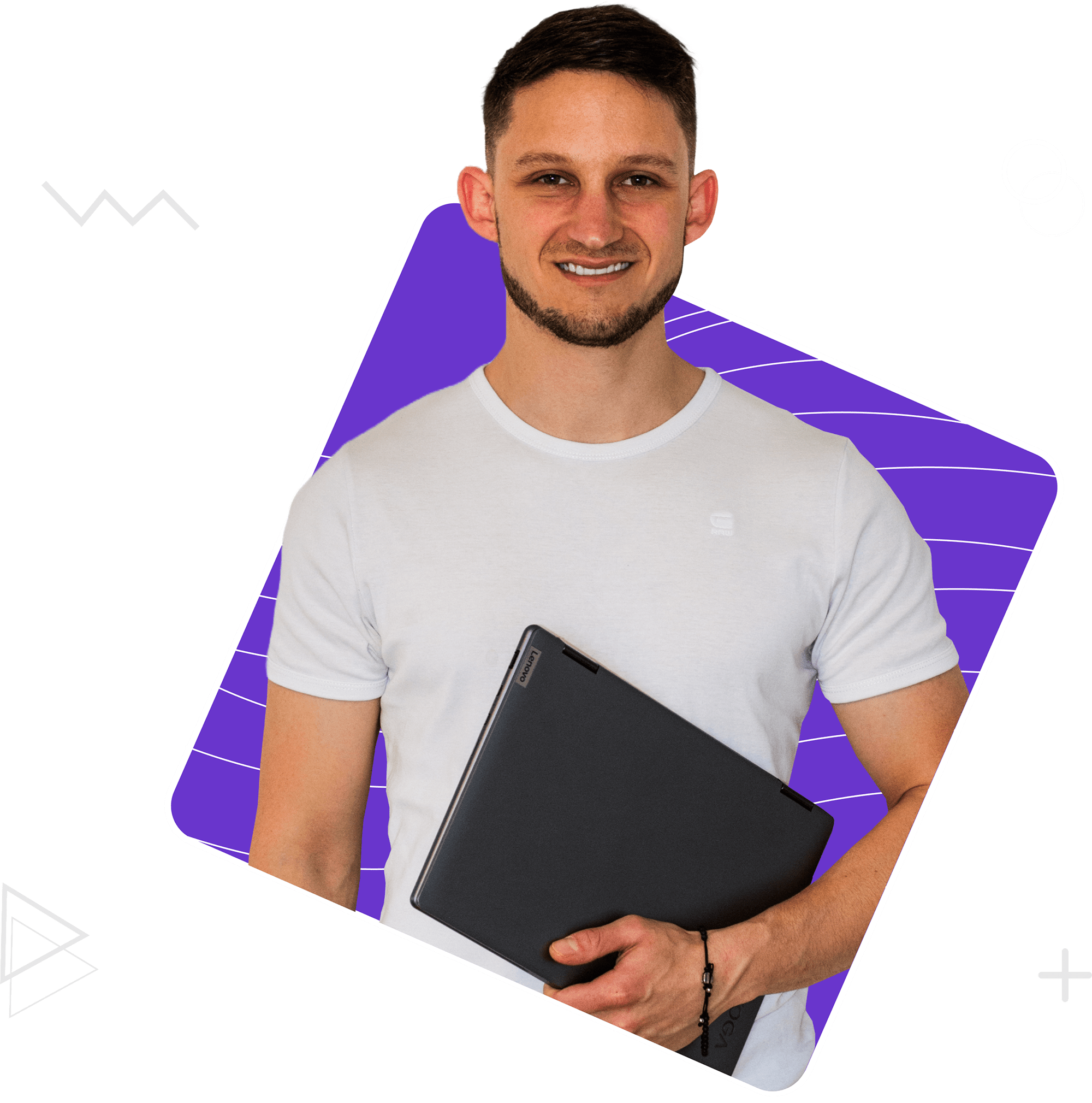 Ein Webdesigner mit Laptop in der Hand schaut in die Kamera.